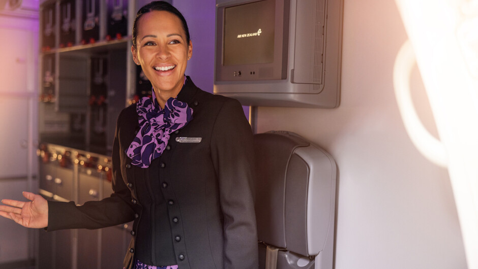 Flight attendant smiling while greeting passengers