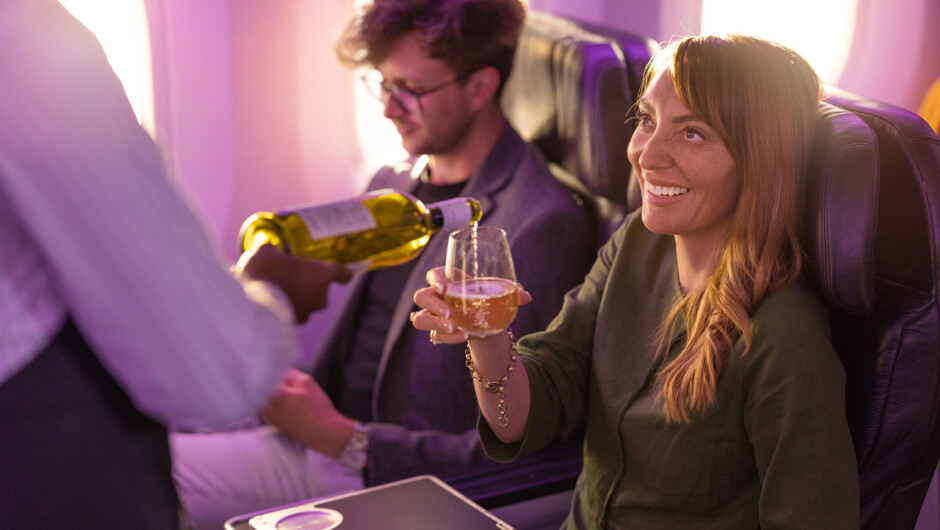 Passenger in premium economy with glass of wine