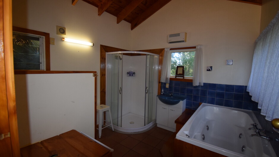 The Kowhai bathroom showing the spa bath and separate shower. The toilet is behind the partition.