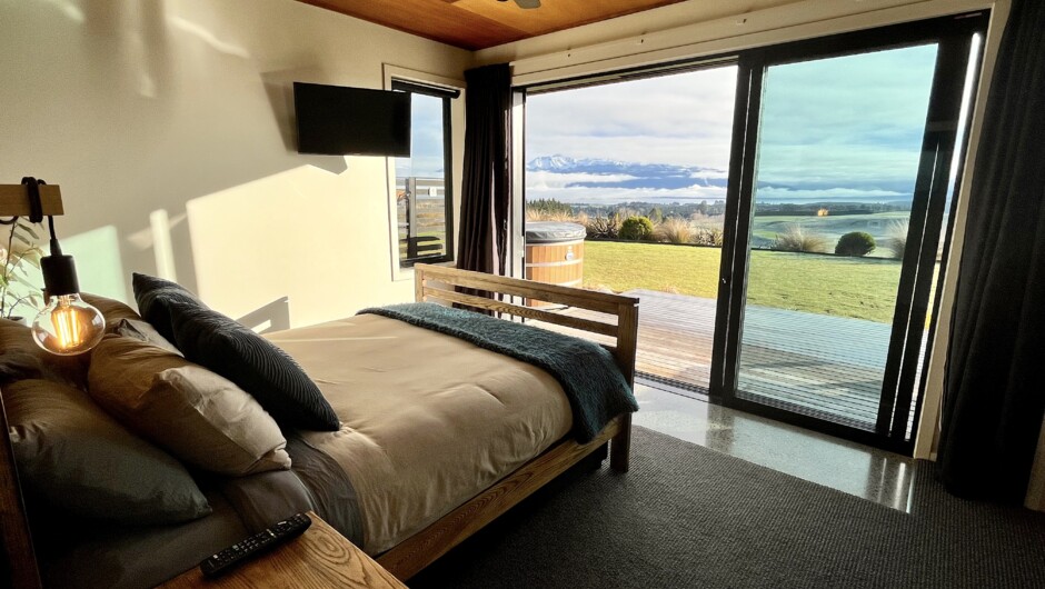 The second bedroom has a queen-sized bed, with stunning, unobstructed views of Lake Te Anau and the Fiordland mountains beyond. Enjoy central heating, ducted air conditioning, blackout curtains and Satellite TV (including Netflix).