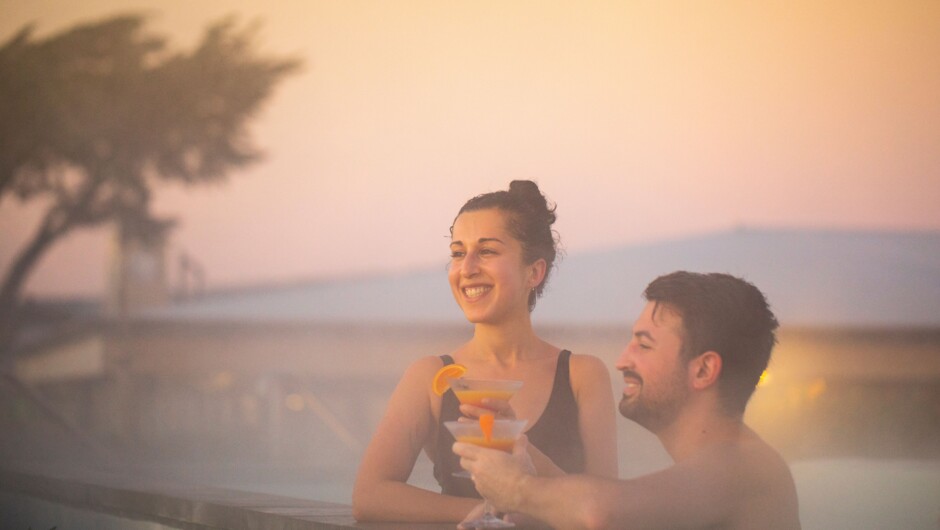 Couple enjoying a mocktail looking out at the sunrise.