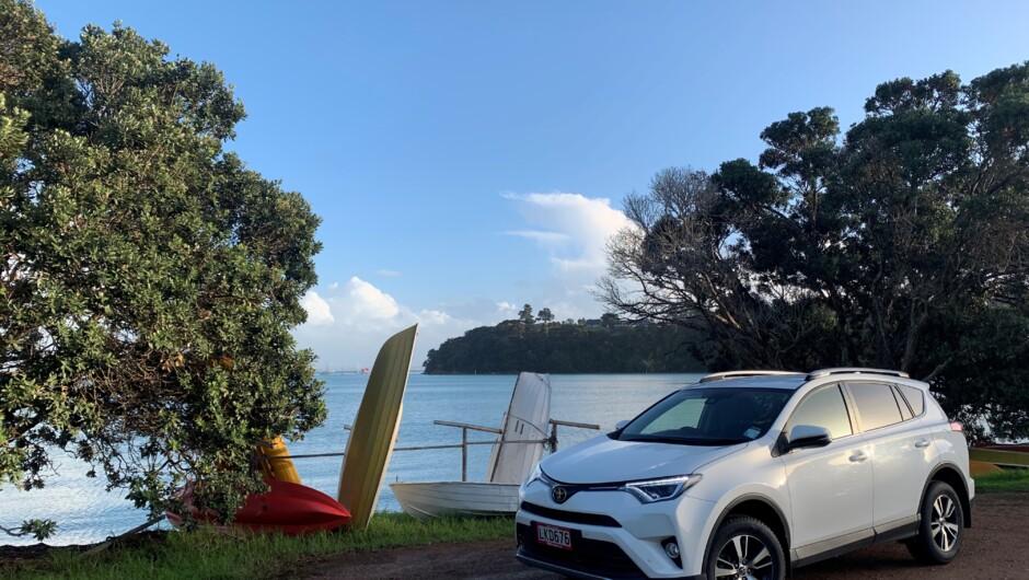 GO Rentals vehicle parked up beside beach landscape.