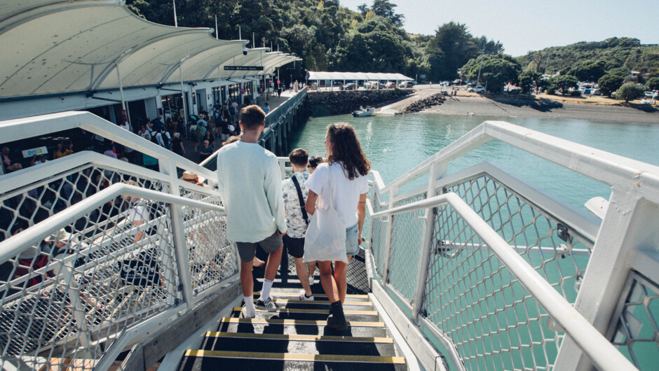 People walking downstairs and onto the pier at Matiatia Wharf ferry terminal on Waiheke Island
