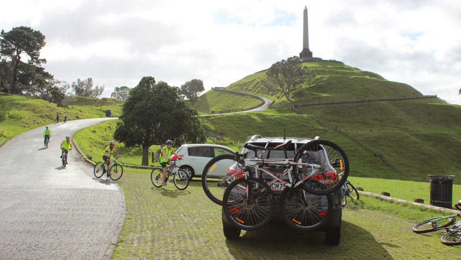 GO Rentals vehicle with bikes on bike rack parked at bottom of Mt Eden with children riding their bikes down the pathway.