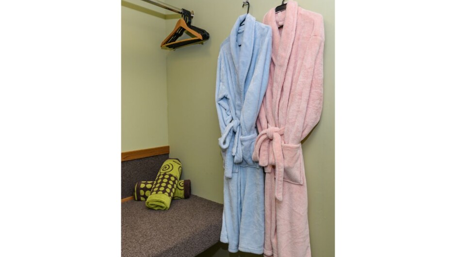 Big luggage rack in bedroom with cosy dressing gowns and extra spa towels
