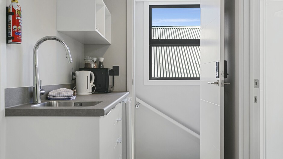 Upstairs Loft Hideaway - Kitchenette equipped with a fridge/freezer, toaster, jug, microwave, and kitchen utensils and cutlery