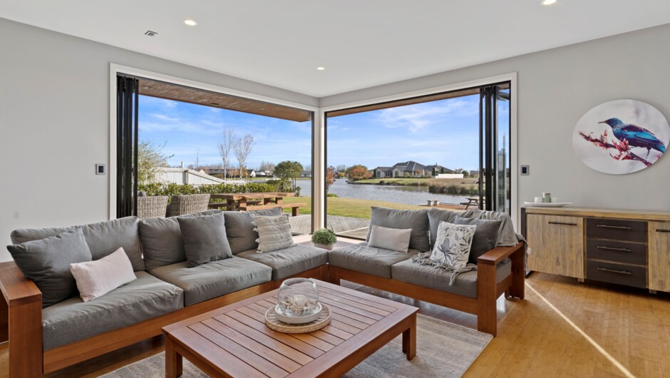 A welcoming lounge seamlessly connects to the outside space and down to the private jetty..