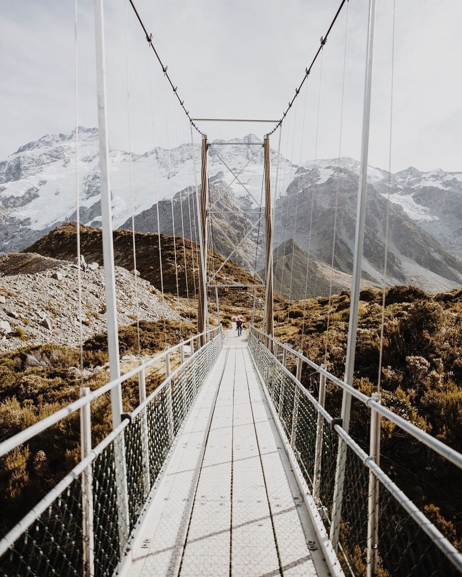 The Hooker Valley Track crosses suspension bridges over the Hooker River before reaching a lookout for a close view of Aoraki/Mount Cook.
