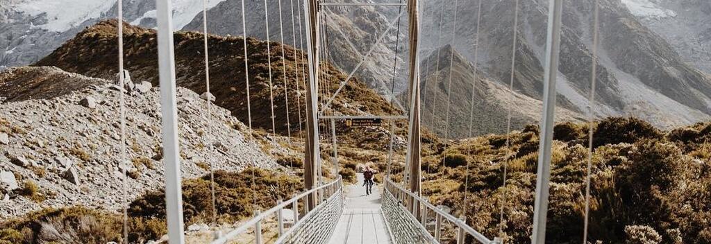 The Hooker Valley Track crosses suspension bridges over the Hooker River before reaching a lookout for a close view of Aoraki/Mount Cook.