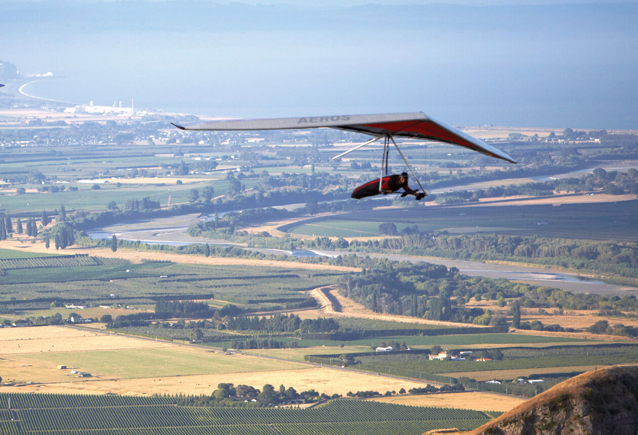 Paragliding in New Zealand - Soar above breathtaking landscapes as you combine the thrills of hang-gliding and parachuting.