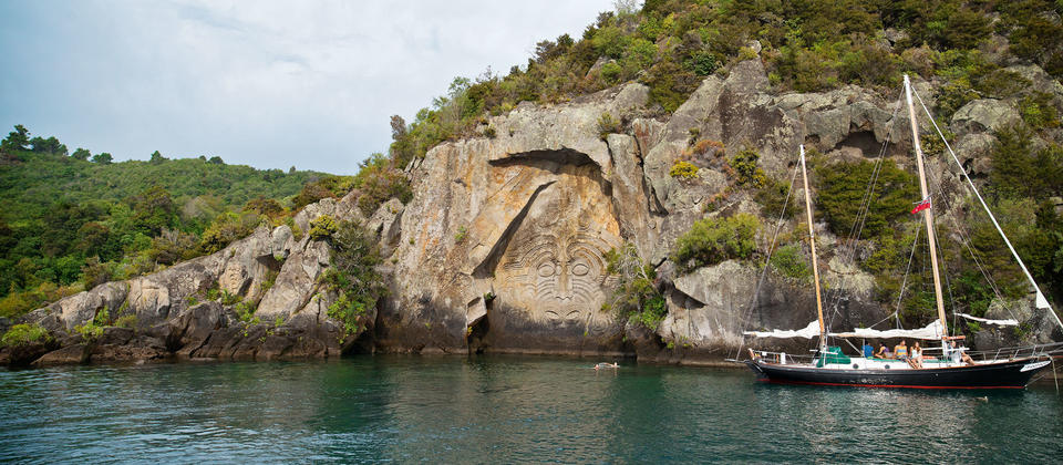 Berlayarlah untuk melihat pahatan suku Maori di Mine Bay.