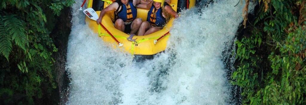 Whitewater rafters brace themselves for a waterfall while rafting the Kaituna River