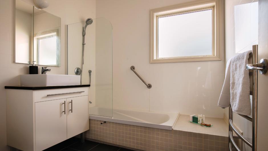 The main bathroom features a bath/shower, basin, toilet, heated floor and heated towel rail.