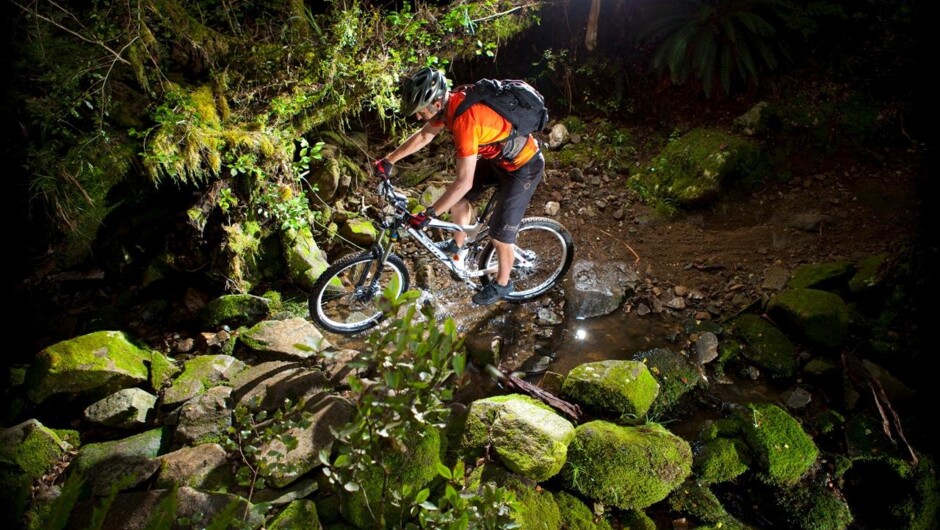 Riding through a creek on the Rameka Track in Golden Bay