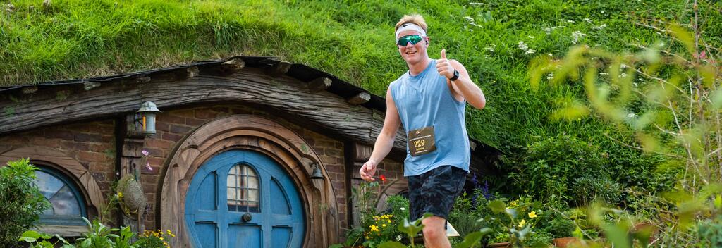 Runner in front of a hobbit house at Middle-Earth Halfing Marathon