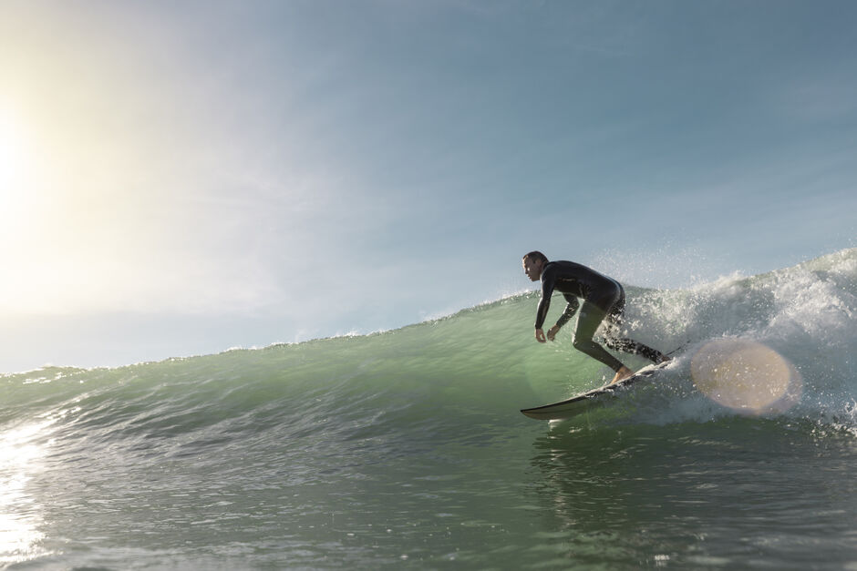 Surfer riding a wave at Wainui Beach in Gisborne