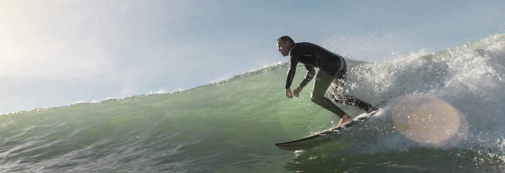 Surfer riding a wave at Wainui Beach in Gisborne