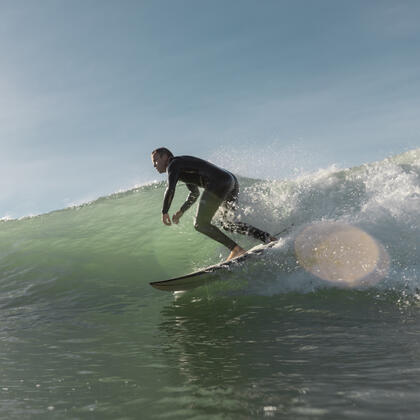 Surfer riding a wave at Wainui Beach in Gisborne