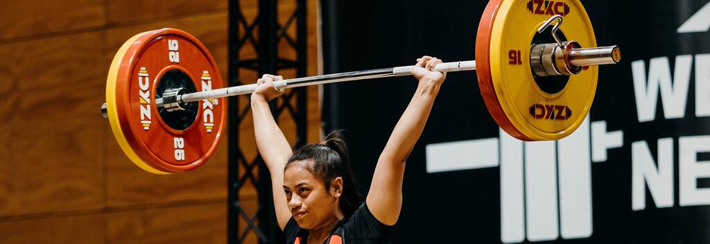 Weightlifting athlete lifting a barbell overhead at the weightliftinh festival in New Zealand