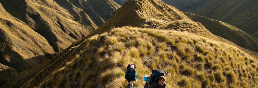 Along the trail, hikers trek through uninhabited wilderness on the Motatapu Alpine track