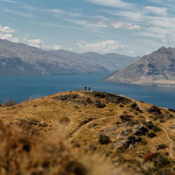 Hikers admiring views on Lake Wakatipu and surrounding mountains from the top of Quenstown Hill track
