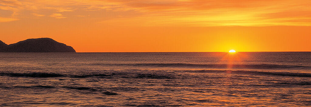 Sonnenaufgang am Wainui Beach, Gisborne.