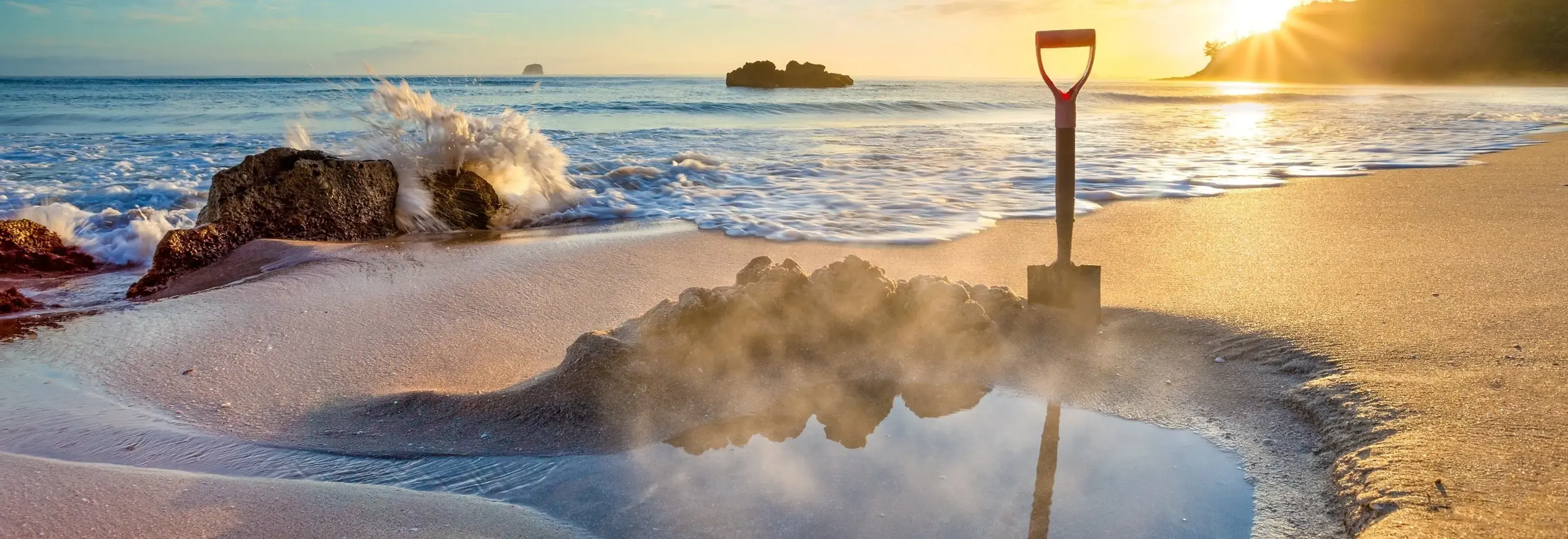 Golden sunset illuminates Hot Water Beach with steaming natural thermal pools in sand.