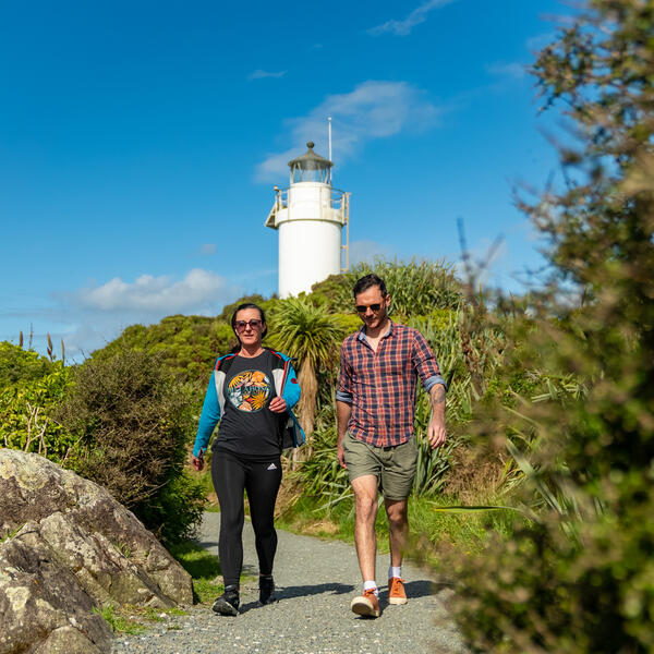 Couple walking along Cape Foulwind Lighthouse on the West Coast