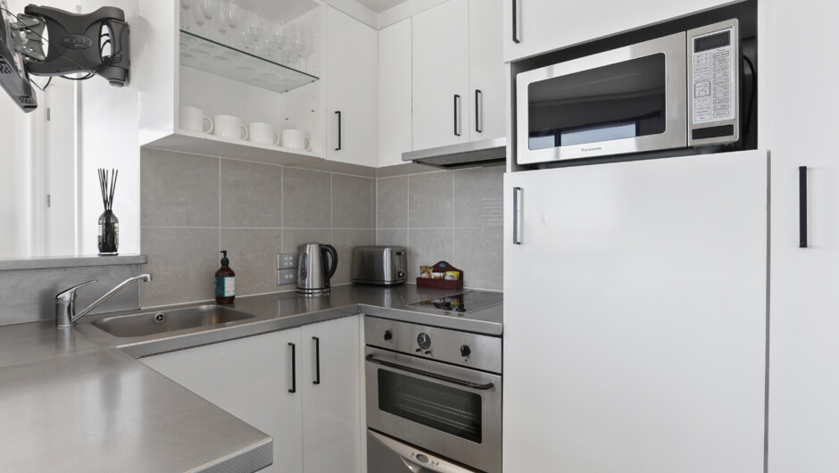 Kitchen comes fully equipped with cooking necessities such as a cooktop, oven, microwave, refrigerator, and a dishwasher.