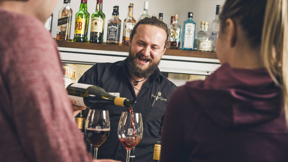 Bartender pouring wine at Punga Cove bar