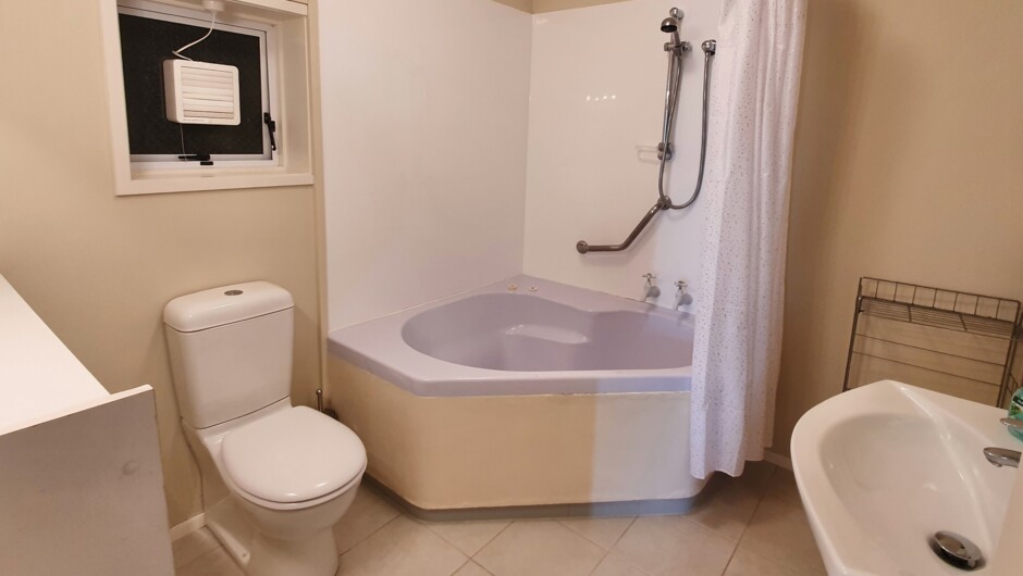 Bathroom with shower over bath, toilet &amp; vanity