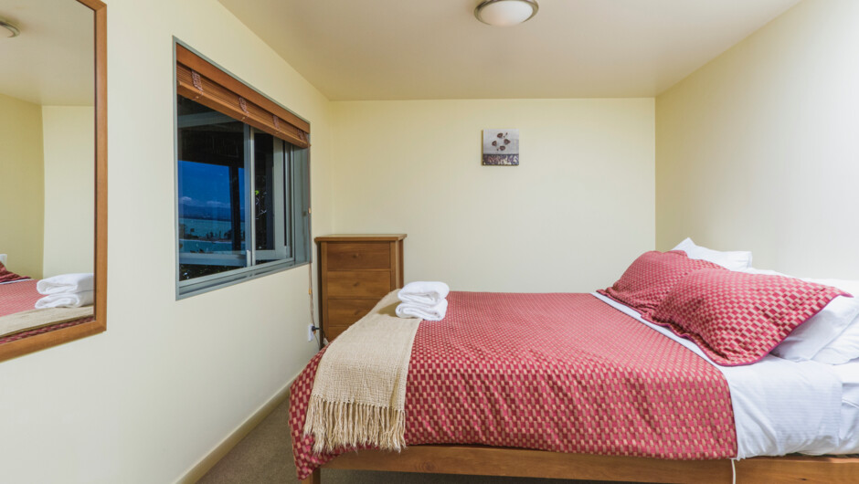 Bedroom with queen bed & views over Tasman Bay & the Harbour entrance
