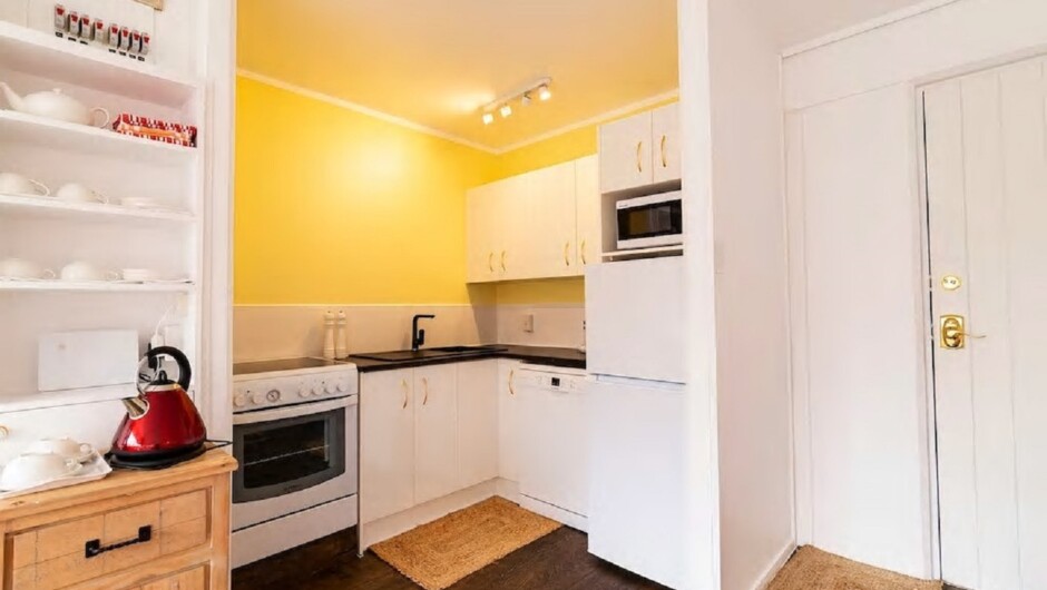 The kitchen is equipped with a fridge/freezer, dishwasher, oven, microwave, kettle, toaster, utensils and crockery.