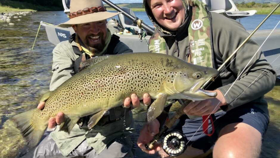 Head guide Scott Slater with client Charlie holding a monster dry fly eating trophy brown before release on an Edge of Fiordland Float Trip.