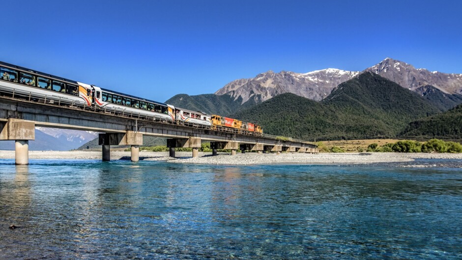 The TranzAlpine passing through the Southern Alps in springtime.