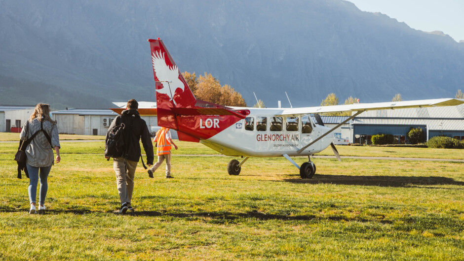 Glenorchy Air's Stewart Island Fly | Explore | Fly ex Queenstown passengers heading out to the aircraft at Queenstown Airport.