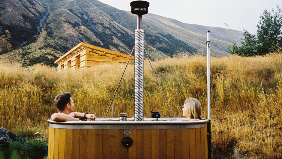 Soaking in the private wood-fired hot tub filled with pure spring water with beautiful mountain views.