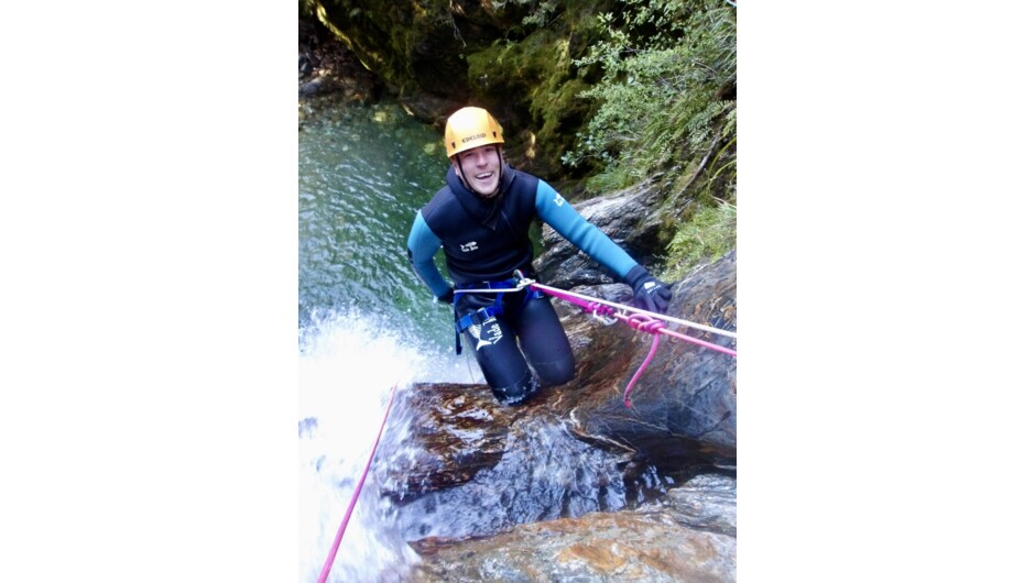 A person getting ready to abseil down the canyon