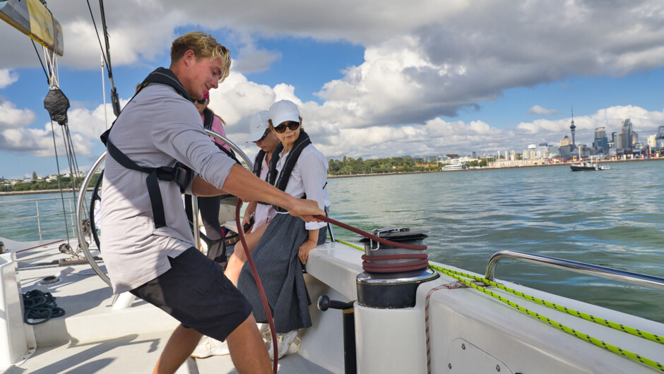 Crew on the winch onboard an America&#039;s Cup Sailing Experience