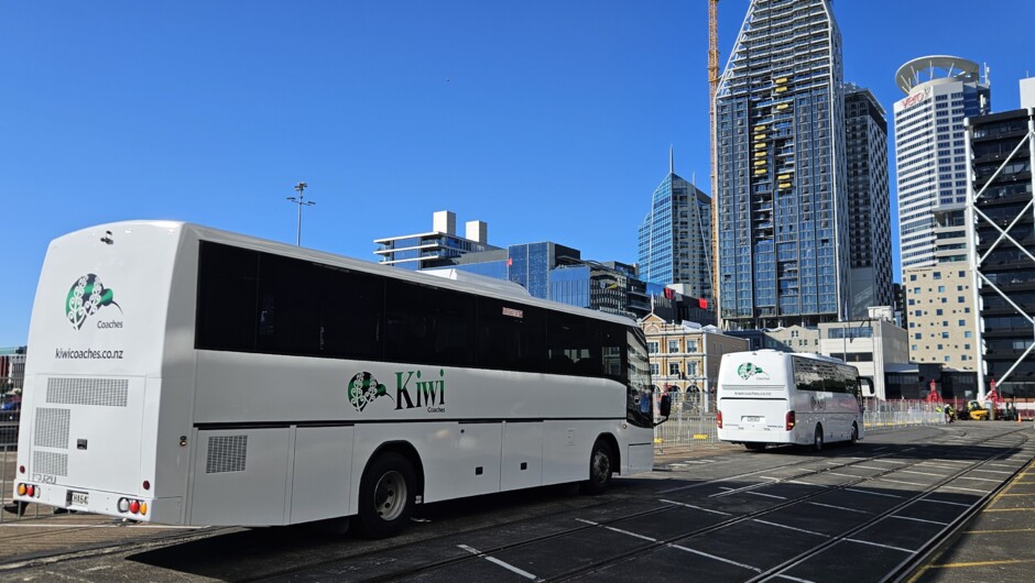 Luxury tour coach interior showing comfortable seats, seatbelts, and microphone system for guided commentary.