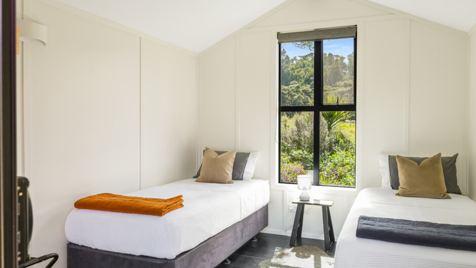 Tui bedroom, which has two singles and is detached, can be booked with Piwakawaka Cottage to sleep 4.