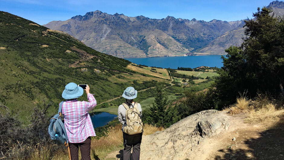 Walkers enjoying the views of Lake Wakatipu and surrounded mountains