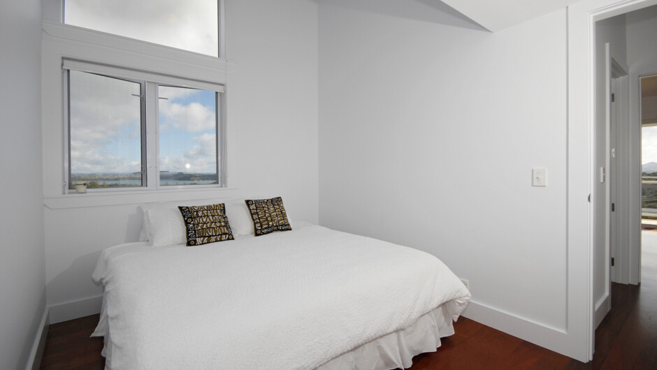Second bedroom with the option of twin singles or a king bed, featuring a ceiling fan for comfort.