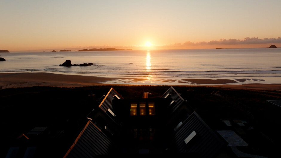 Sunset over Opito Bay, viewed from the private beachfront setting of Opito Point Lodge.