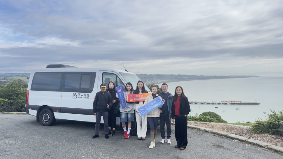 Our seasoned Chinese‑speaking tour guides take group photos with guests of our 8‑person small‑group tours in front of business vehicles marked with the Buer Travel logo.