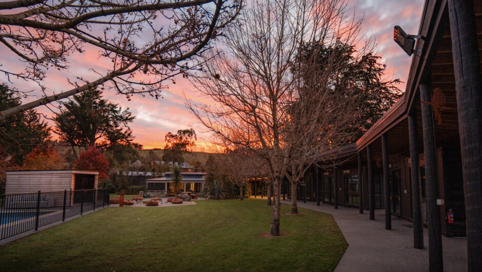Expansive outdoor spaces connecting the seven sleeping pods, the main house, and recovery facilities.
