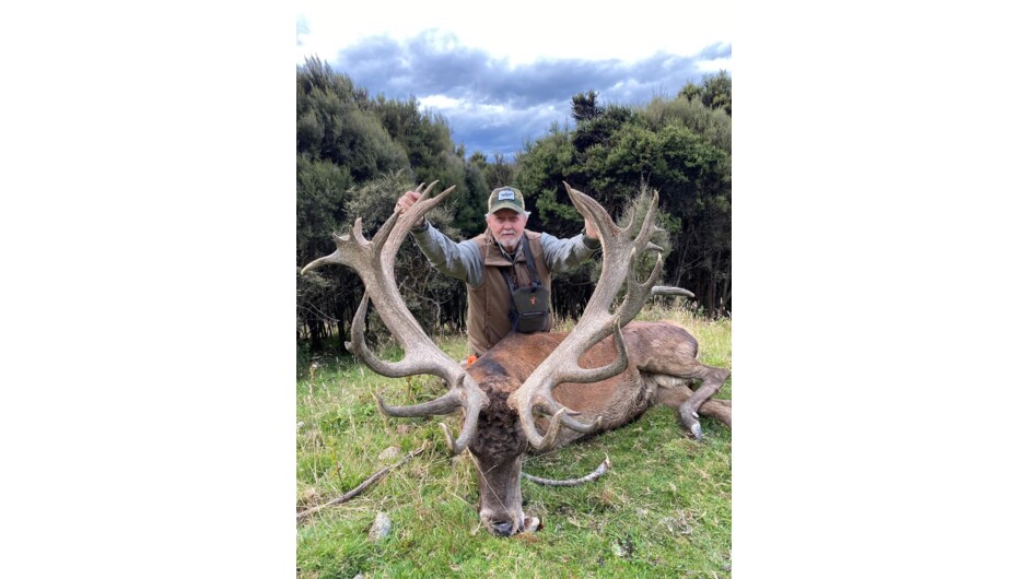 Happy hunter with his gold class trophy red stag