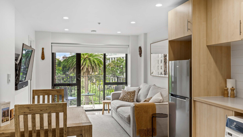 A lounge with a sofa, Smart TV, and access to the private balcony