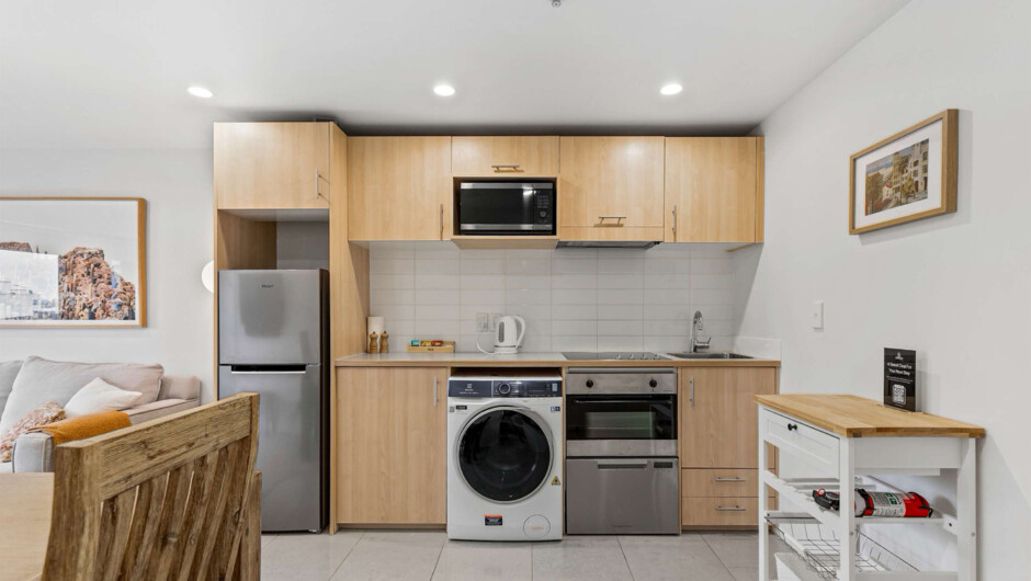 A fully equipped kitchen with a fridge, microwave, oven, dishwasher, stove, blender, Nescafé coffee machine, and Nespresso milk frother