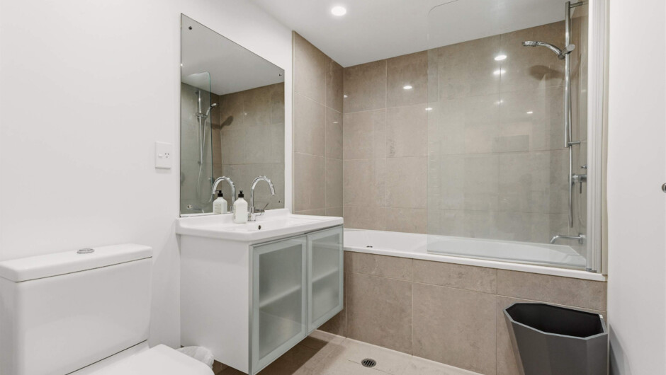 Modern bathroom with tub, fresh towels, and toiletries